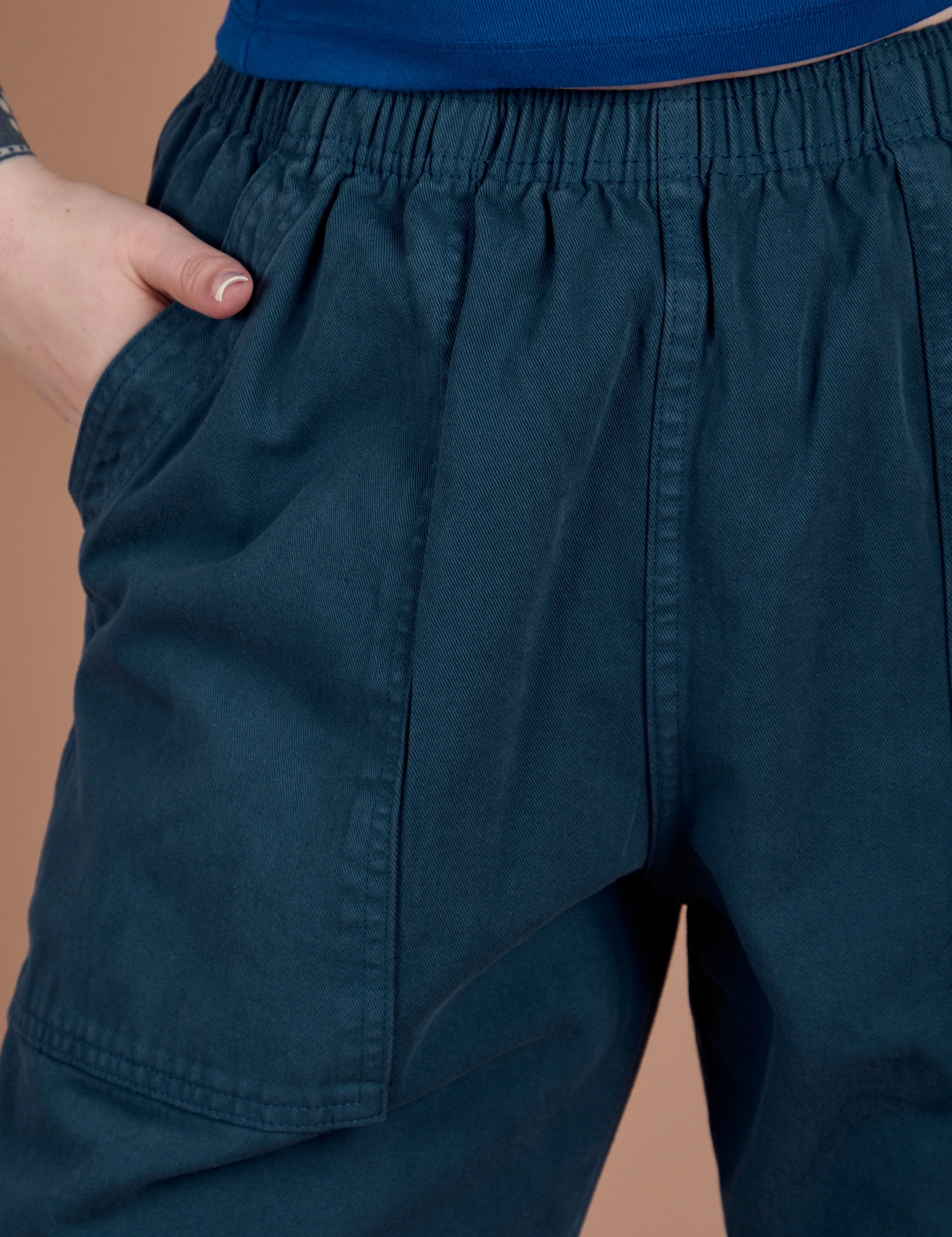 Close up of Sydney's hand in the front pocket of Action Pants in Lagoon