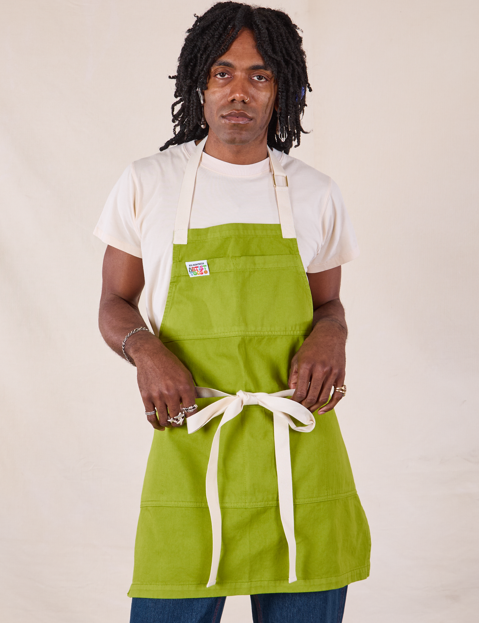 Jerrod is wearing Full Denim Apron in Gross Green