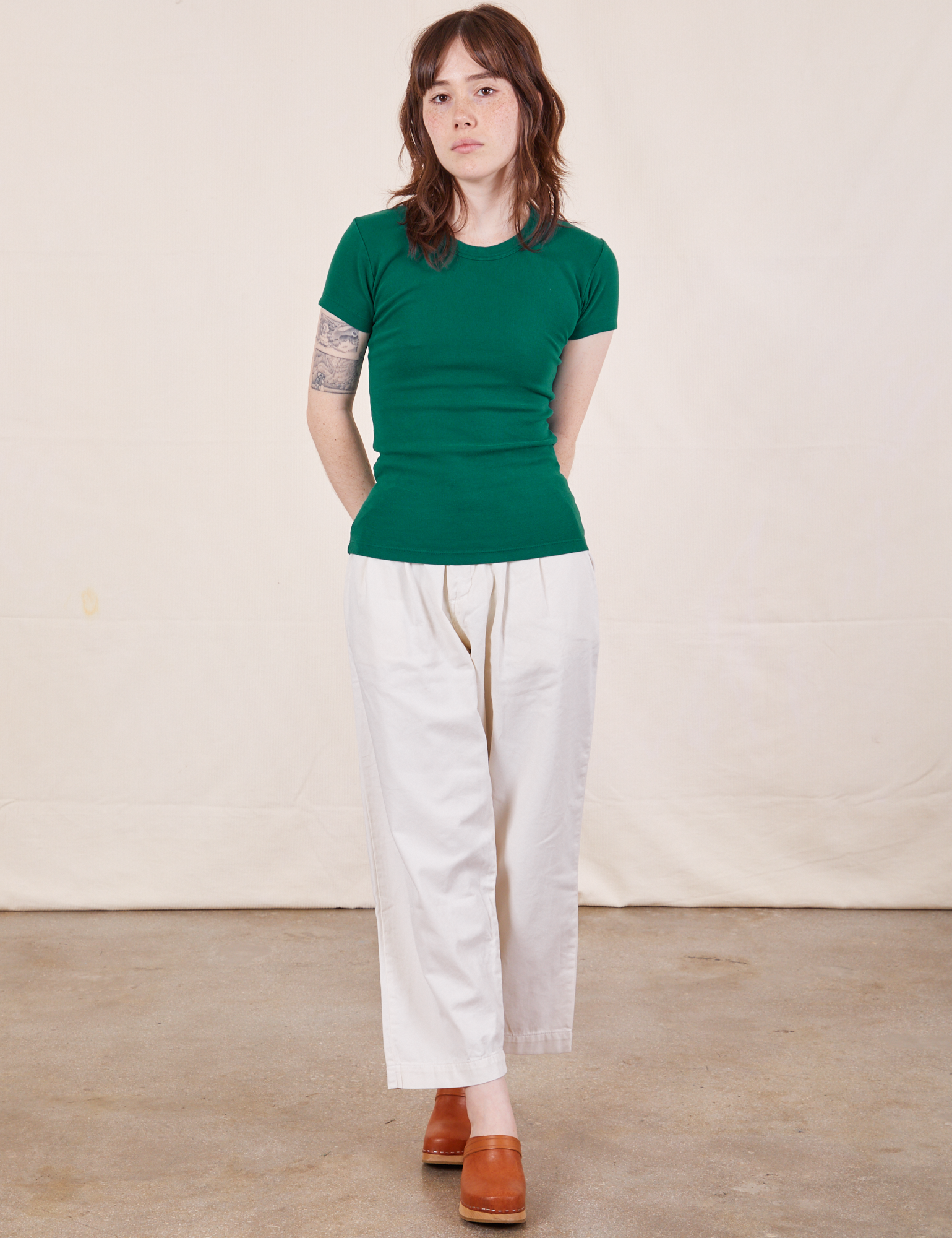 Hana is wearing Baby Tee in Hunter Green and vintage off-white Petite Heavy Weight Trousers