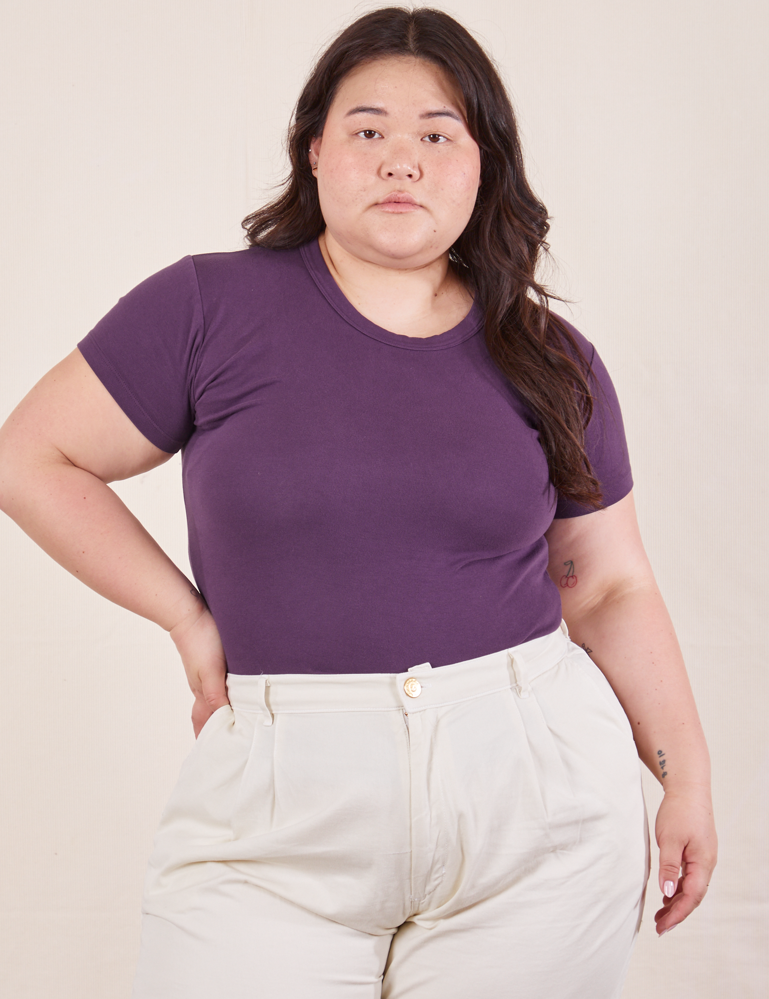 Ashley is wearing Baby Tee in Nebula Purple tucked into vintage off-white Trousers