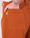 Close up of Betty's hand in the back pocket of Bell Bottoms in Burnt Terracotta