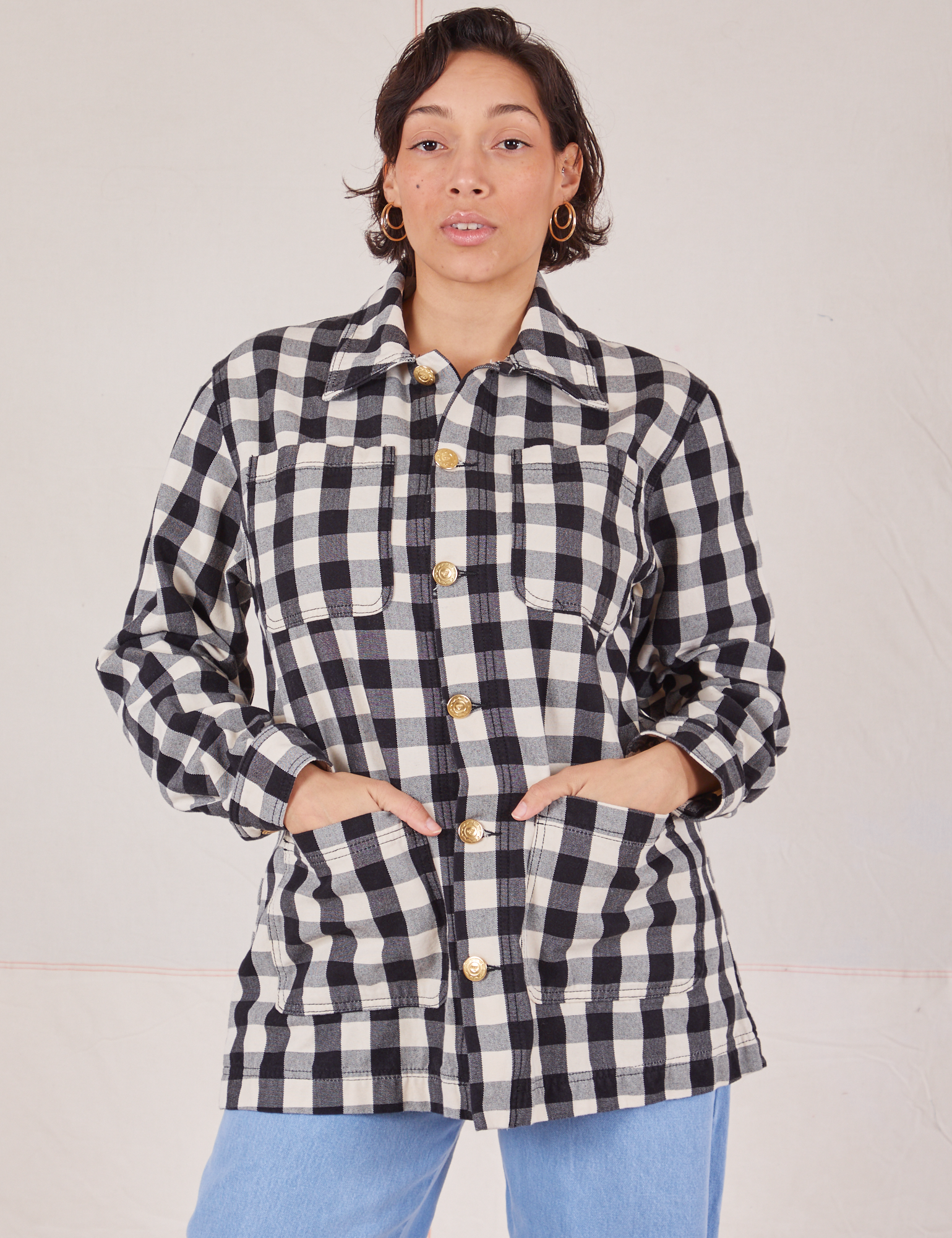Tiara is wearing a buttoned up Big Gingham Field Coat and has her hands in the front pockets