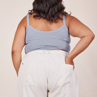 Back view of Cropped Cami in Periwinkle and vintage off-white Western Pants worn by Alicia. She has her right hand in the back pant pocket.