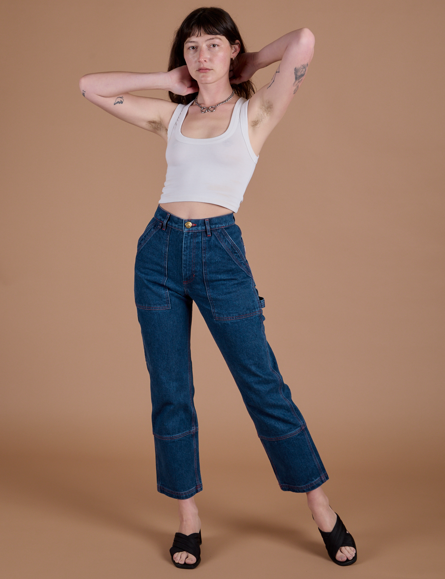Alex is 5’8” and wearing XXS Carpenter Jeans in Dark Wash paired with a Cropped Tank in Vintage Tee White