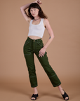 Alex is 5’8” and wearing XXS Carpenter Jeans in Evergreen paired with a vintage tee white Cropped Tank