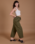 Side view of Drop Pocket Cargo Pants in Surplus Green and Cropped Tank in vintage tee white on Alex