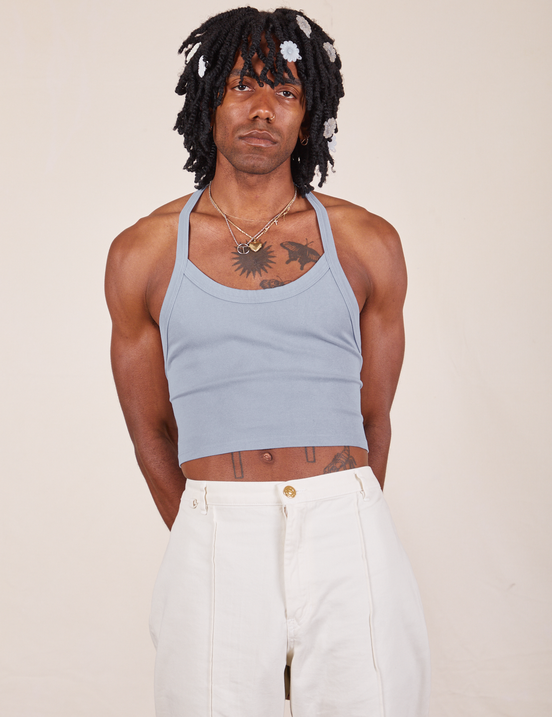 Jerrod is 6'3" and wearing XS Halter Top in Periwinkle paired with vintage off-white Western Pants
