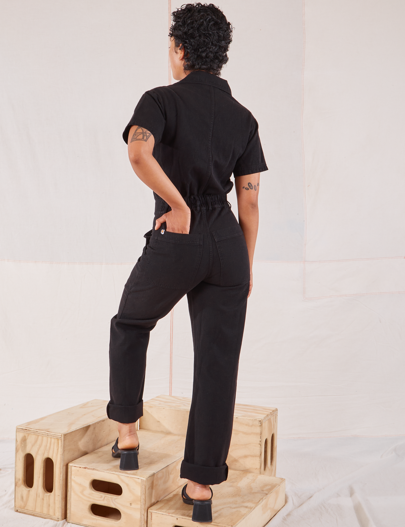 Heritage Short Sleeve Jumpsuit in Basic Black back view on Mika