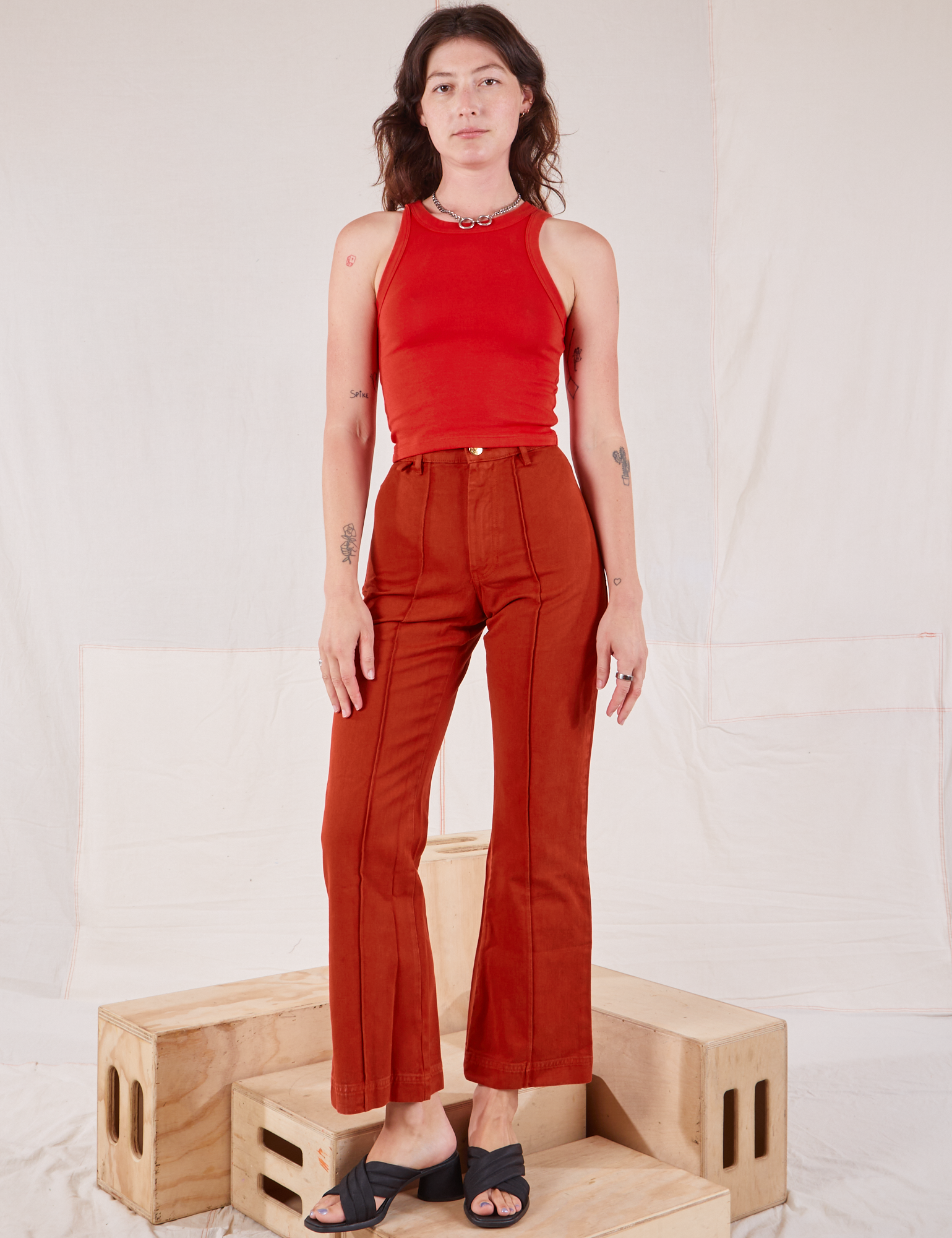 Alex is wearing Racerback Tank in Mustang Red and paprika Western Pants