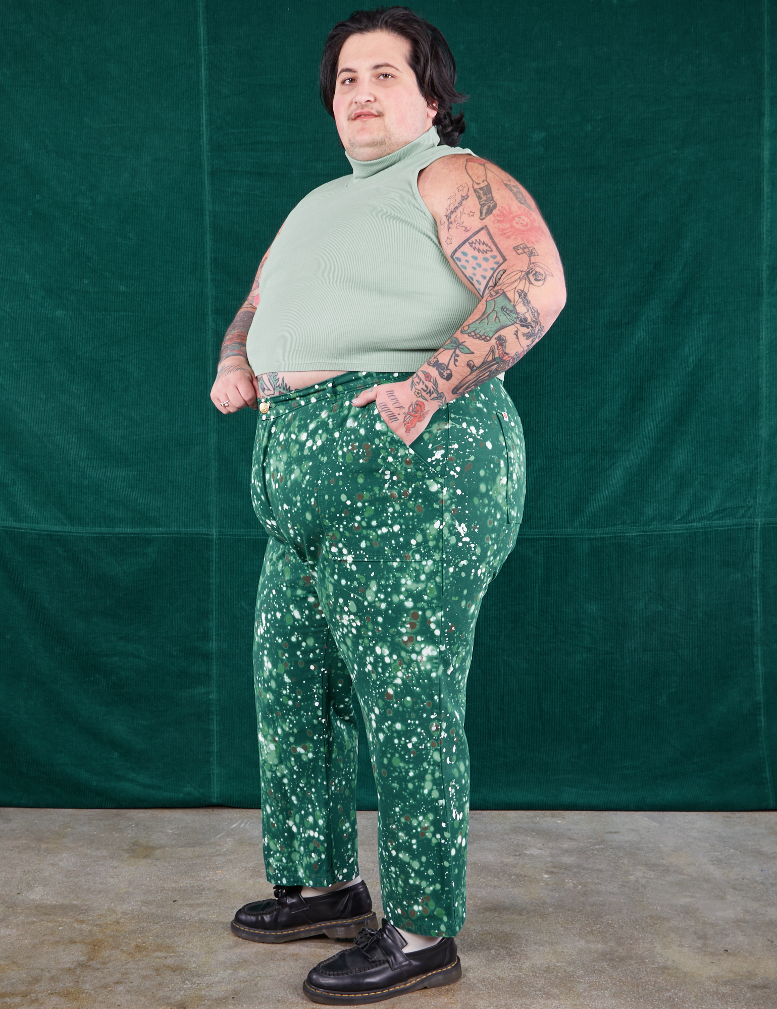 Side view of Marble Splatter Work Pants in Hunter Green and sage green Sleeveless Turtleneck on Sam