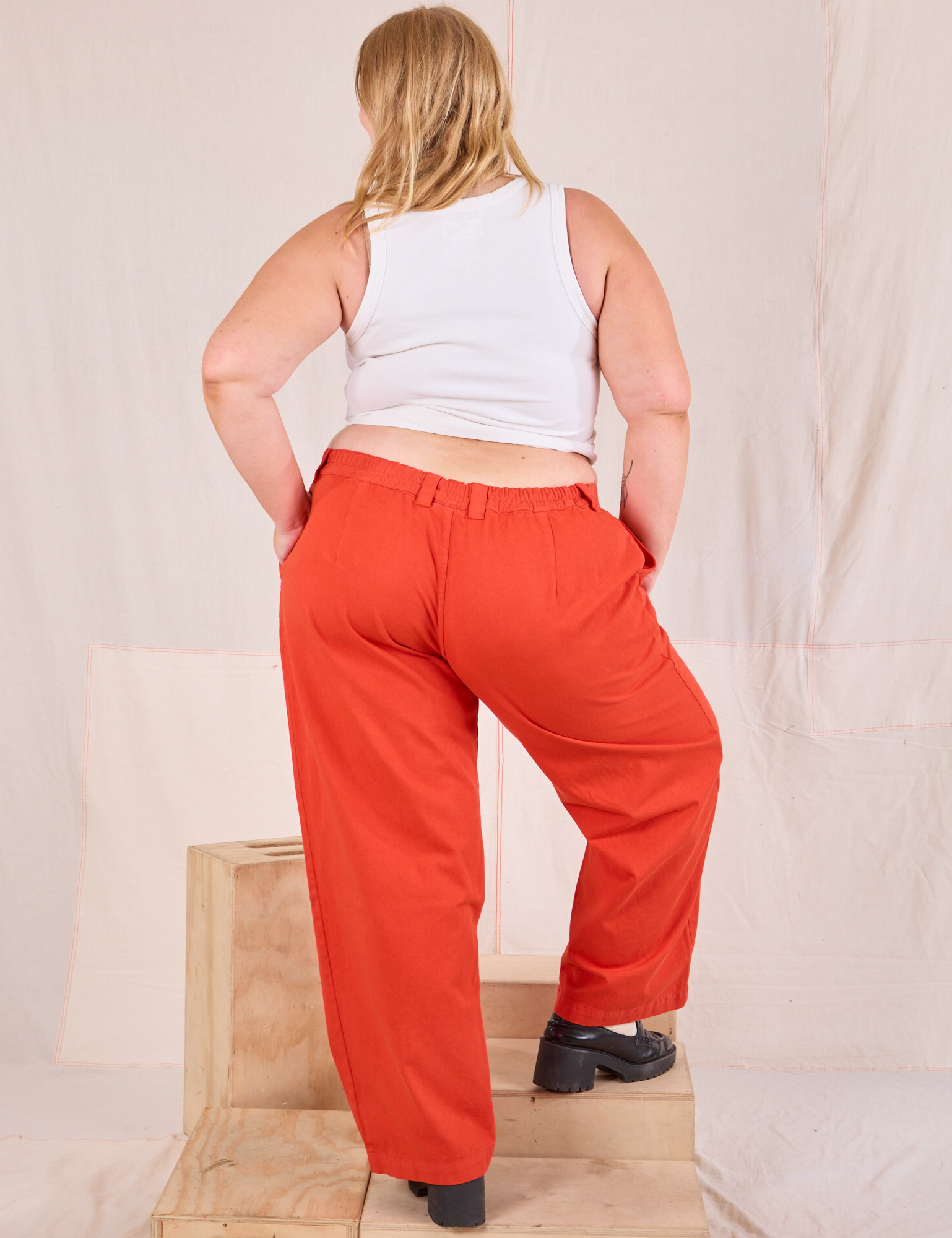 Back view of Mid-Rise Pleated Trousers in Chili Red and Cropped Tank in vintage tee off-white on Juliet