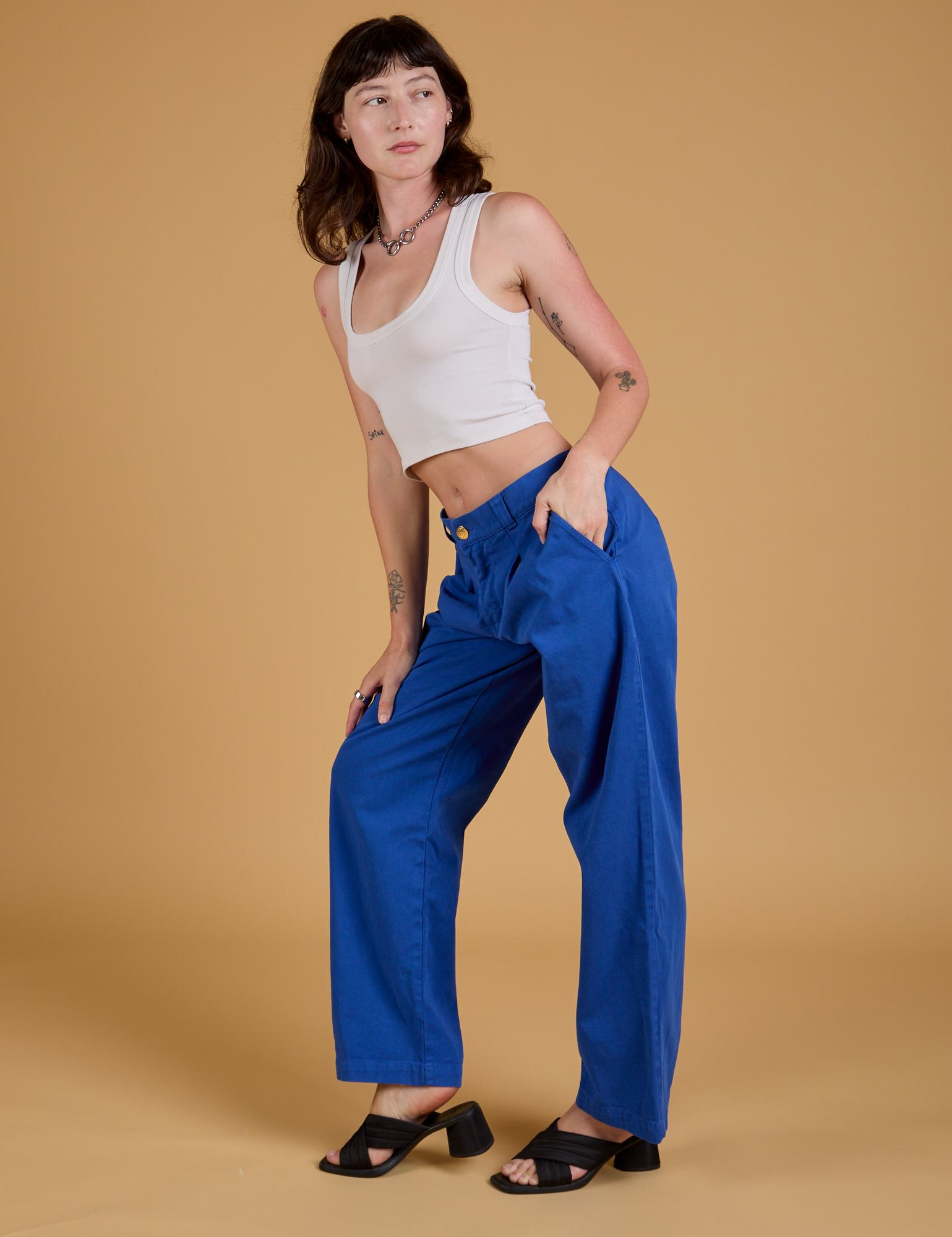 Side view of Baggy Mid-Rise Trousers in Royal Blue and vintage tee white Cropped Tank on Alex