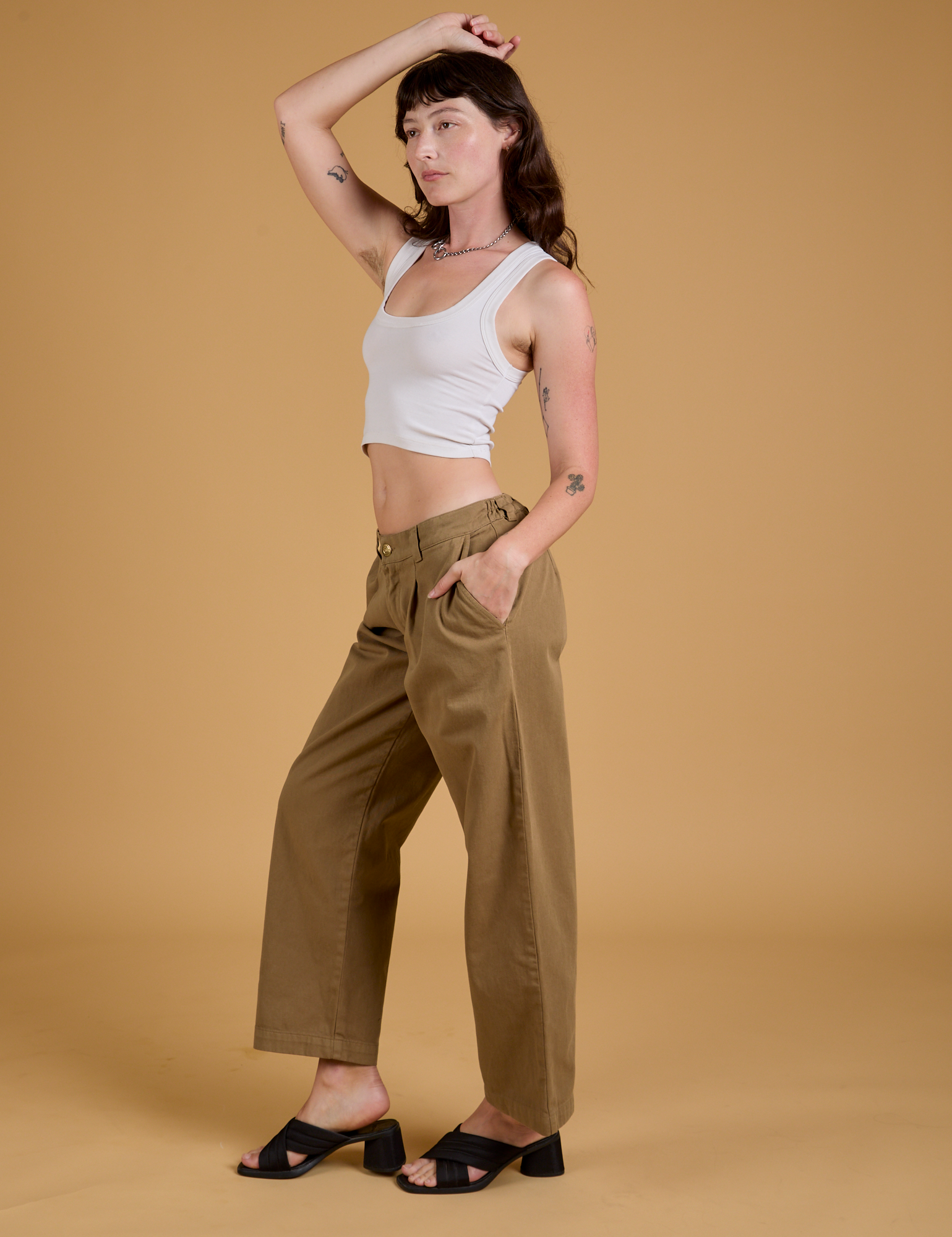 Side view of Baggy Mid-Rise Trousers in Desert Brown and vintage tee white Cropped Tank on Alex