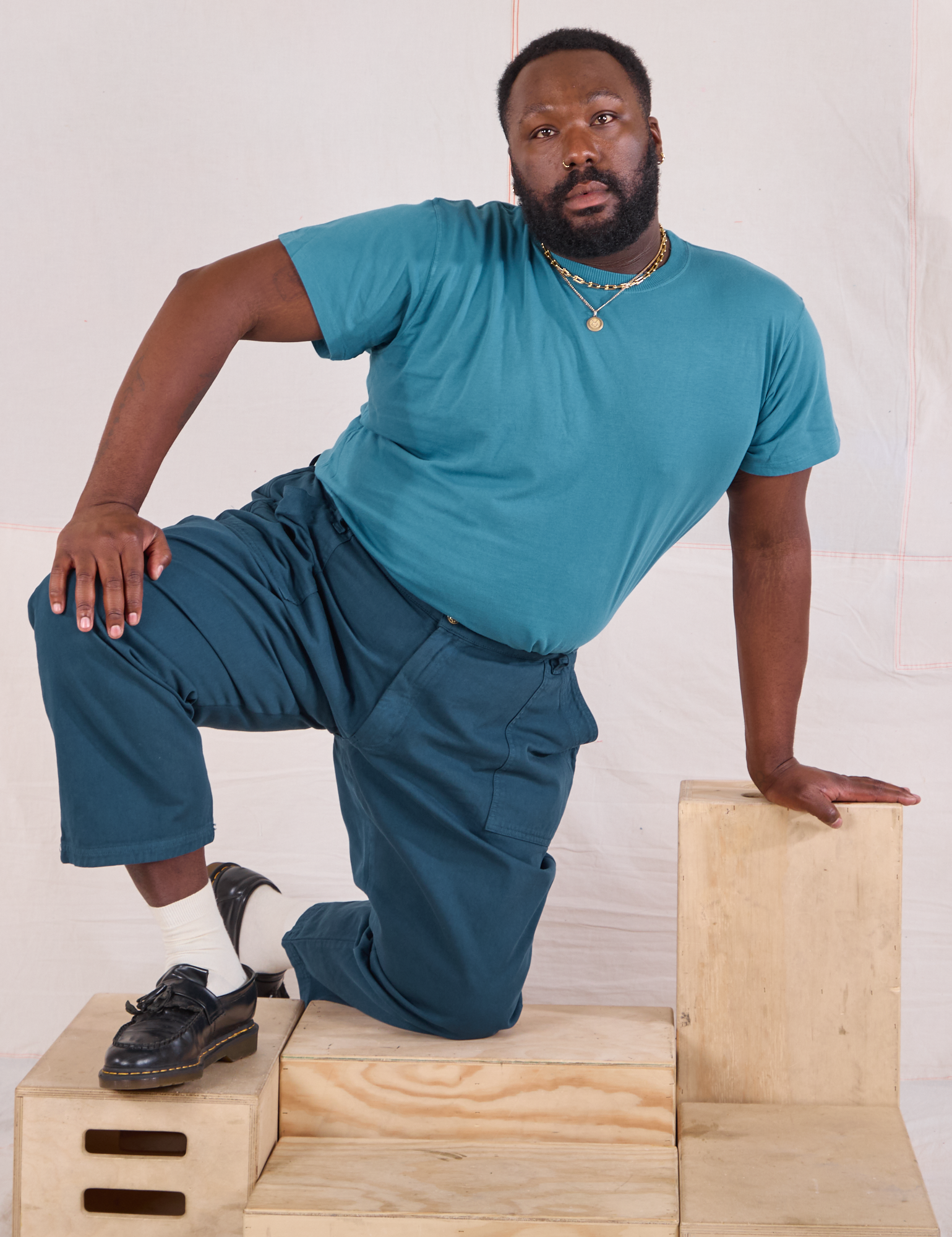 Elijah is wearing Mid-Rise Work Pants in Lagoon and marine blue Organic Vintage Tee