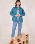 Alex is wearing Oversize Overshirt in Marine Blue, vintage off-white Cropped Tank Top and light wash Frontier Jeans