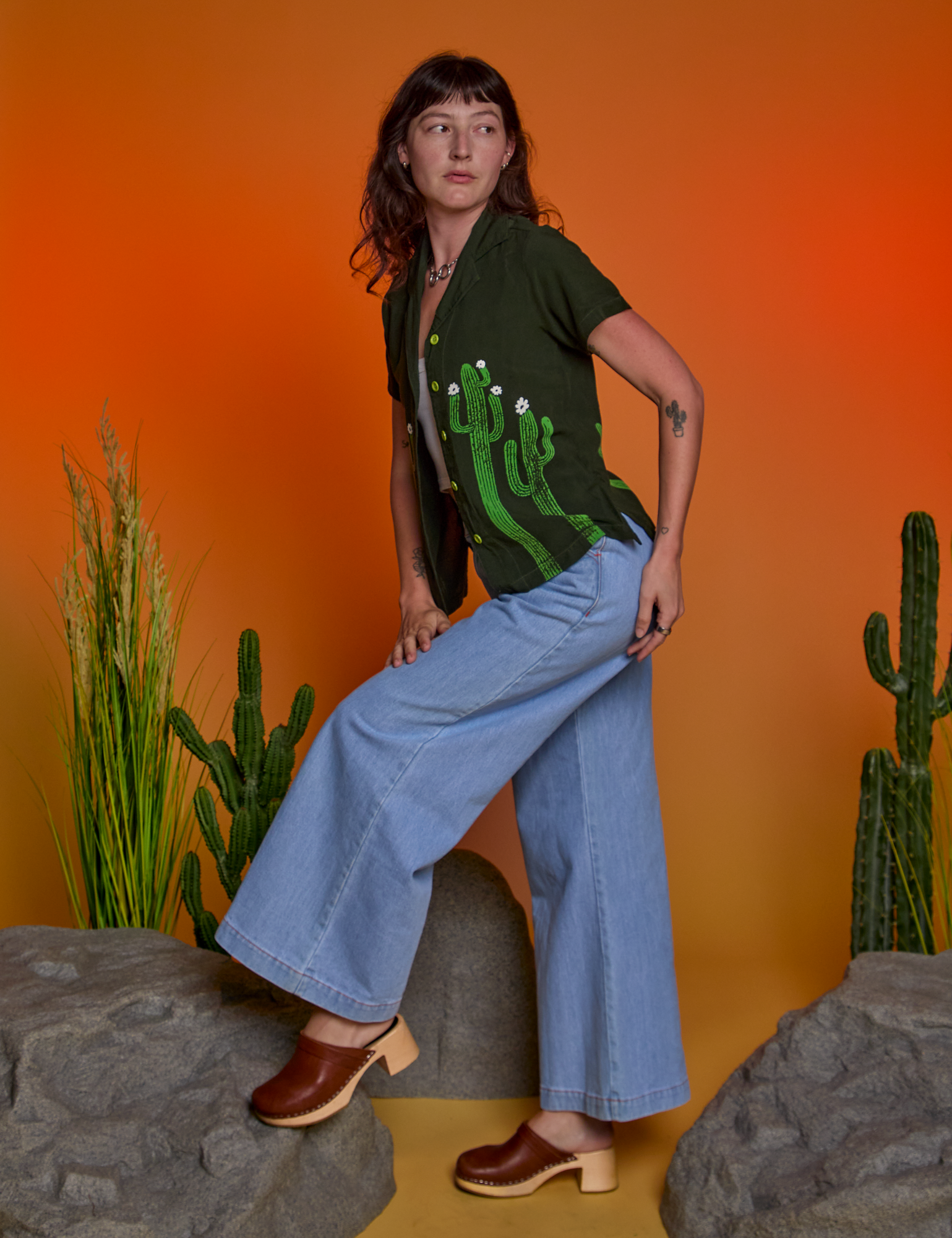 Side view of Paintstamped Pantry Button-Up in Cactus and light wash Indigo Wide Leg Trousers on Alex