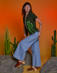 Side view of Paintstamped Pantry Button-Up in Cactus and light wash Indigo Wide Leg Trousers on Alex