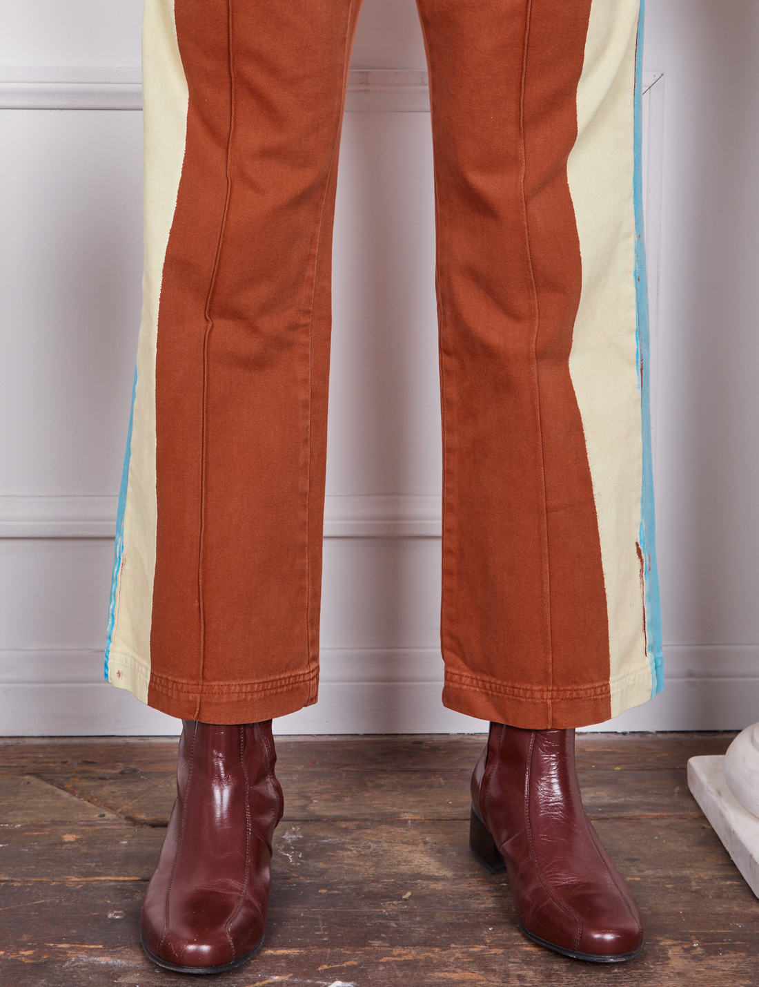 Pant leg close up of Hand-Painted Stripe Western Pants in Burnt Terracotta worn by Gabi