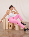 Tiara is sitting on a wooden crate. She is wearing Pencil Pants in Bubblegum Pink and vintage off-white Cropped Cami
