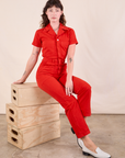 Alex is wearing Short Sleeve Jumpsuit in Mustang Red