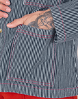 Front pocket close up of Railroad Stripe Denim Work Jacket. Jesse has their hand in the pocket.
