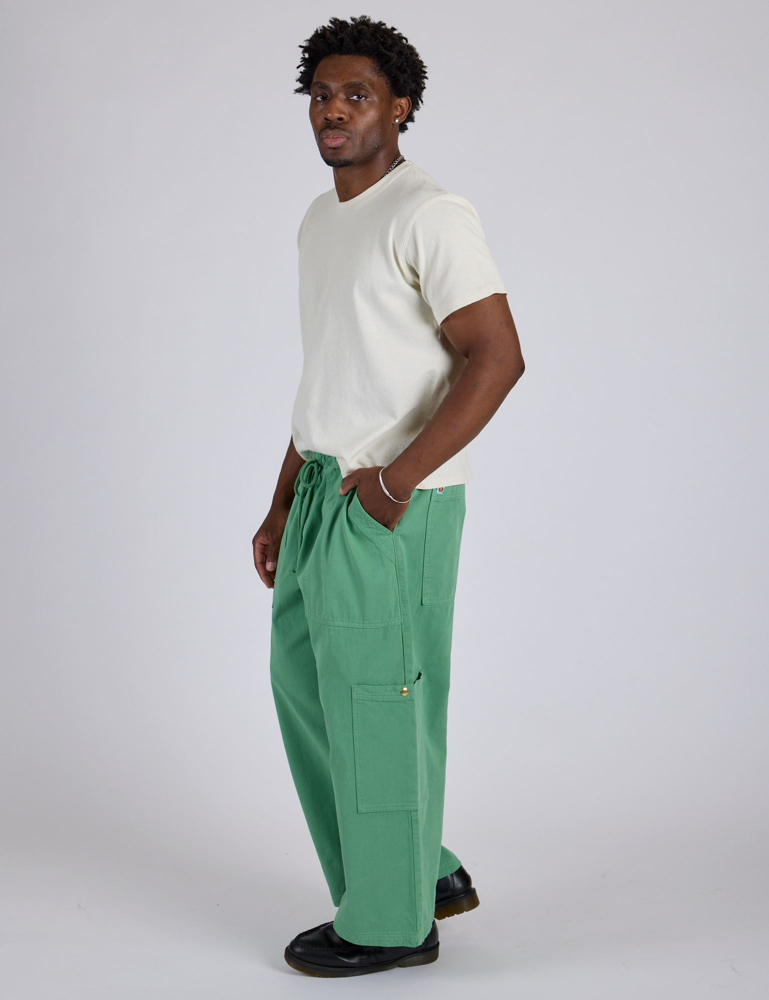 Side view of Drop Pocket Cargo Pants in Seafoam Green and Organic Vintage Tee in Vintage Tee White on Isaac