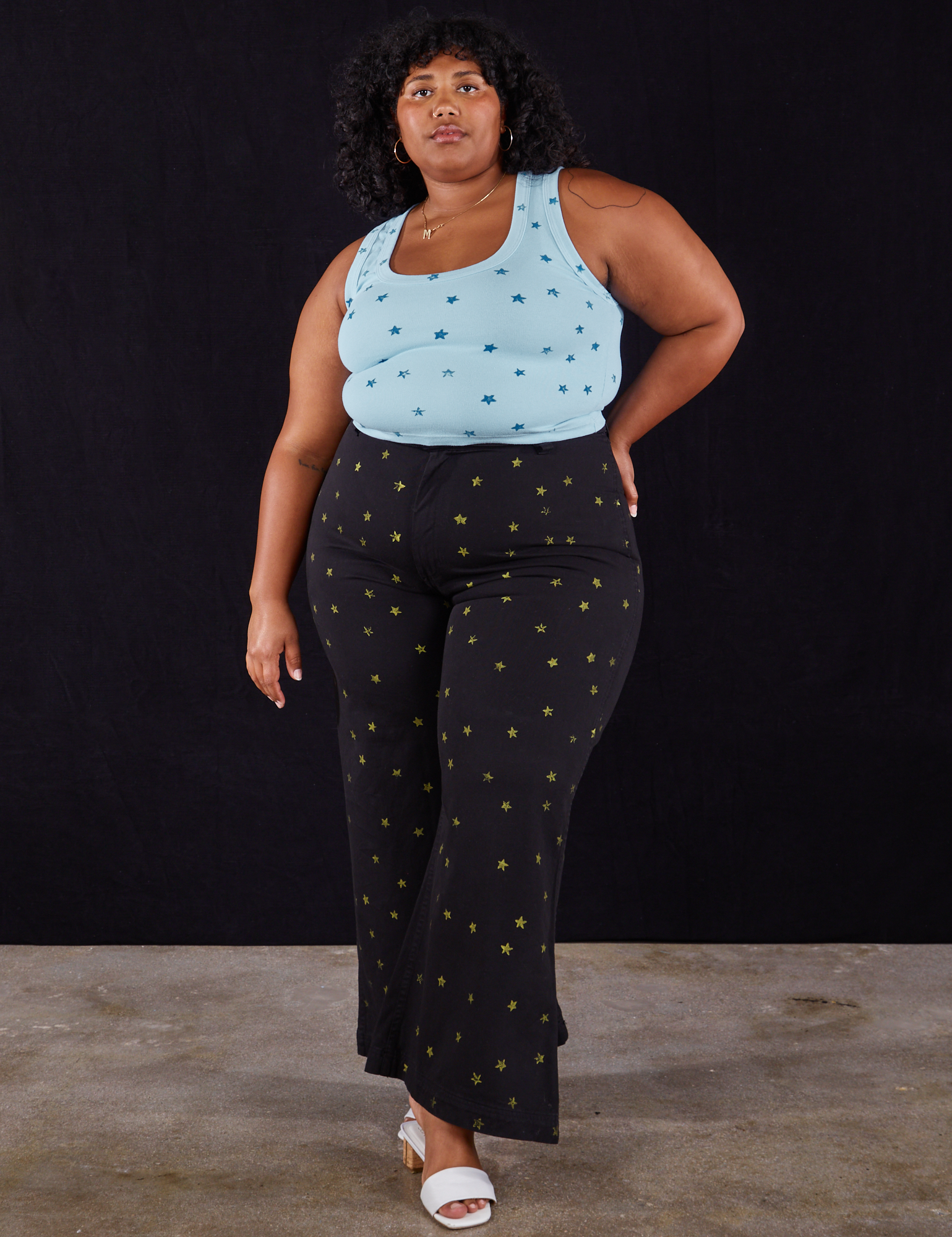 Morgan is wearing Star Bell Bottoms in Black and Star Tank Top in blue