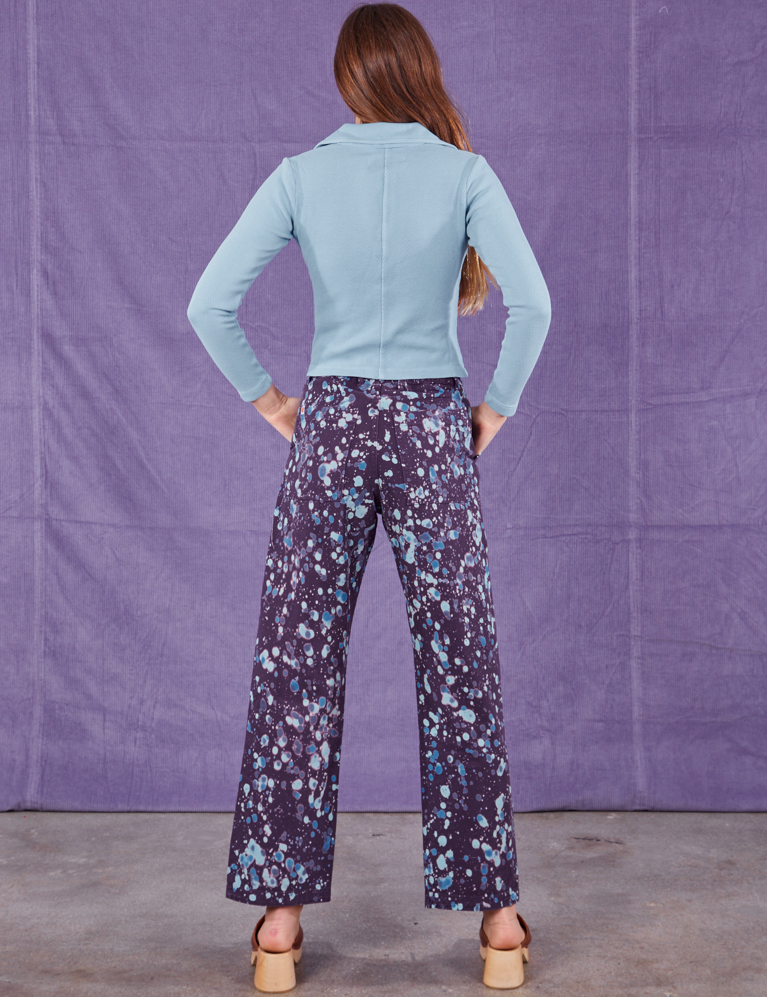 Back view of Marble Splatter Work Pants in Nebula Purple and baby blue Long Sleeve Fisherman Polo on Scarlett