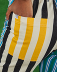 Mismatched Stripe Work Pants back pocket close up. Kandia has her hand in the pocket.