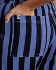 Close up of Tiara's hand in the back pocket of Black Stripe Work Pants in Cornflower Blue