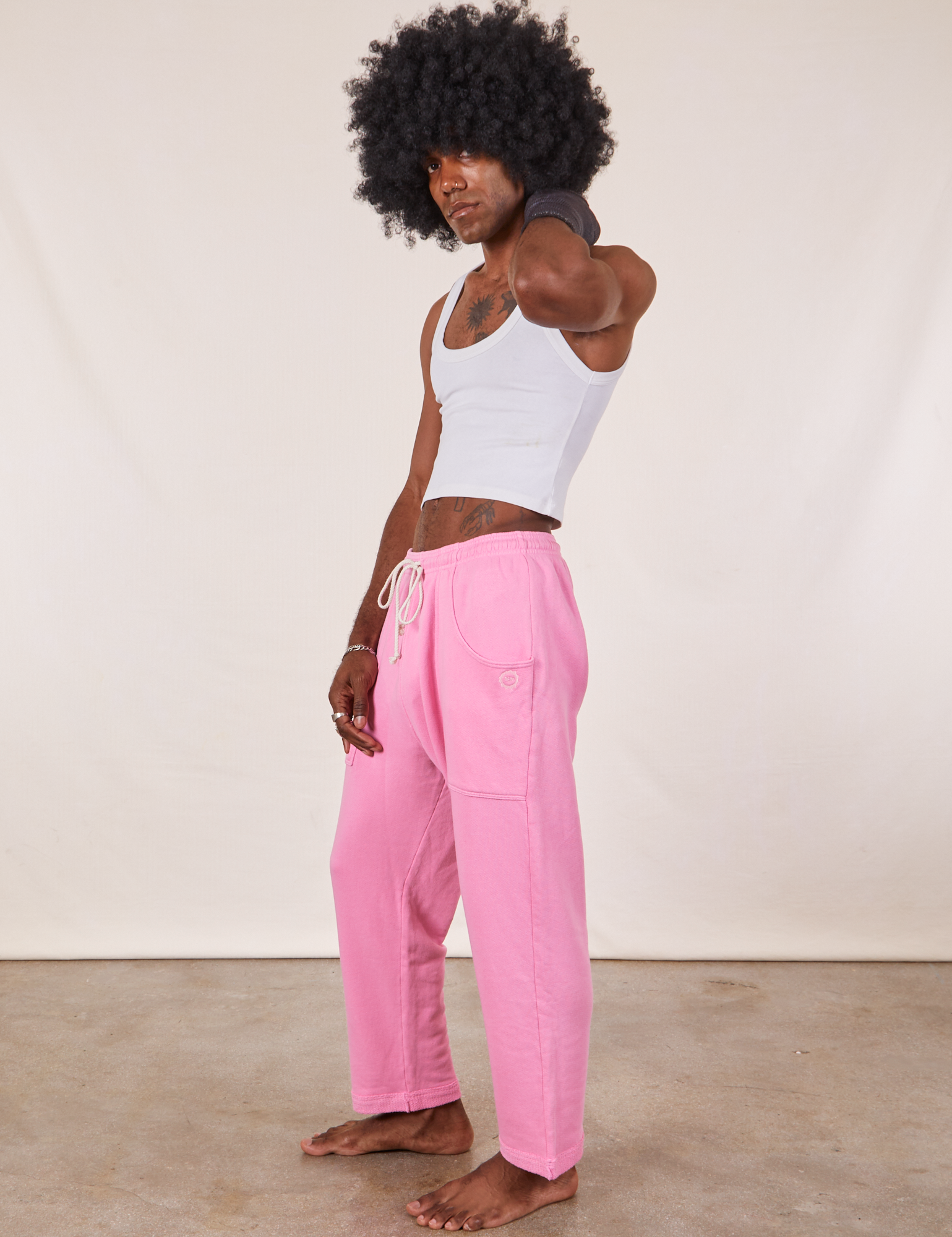 Side view of Cropped Rolled Cuff Sweatpants in Bubblegum Pink and vintage off-white Cropped Tank Top on Jerrod