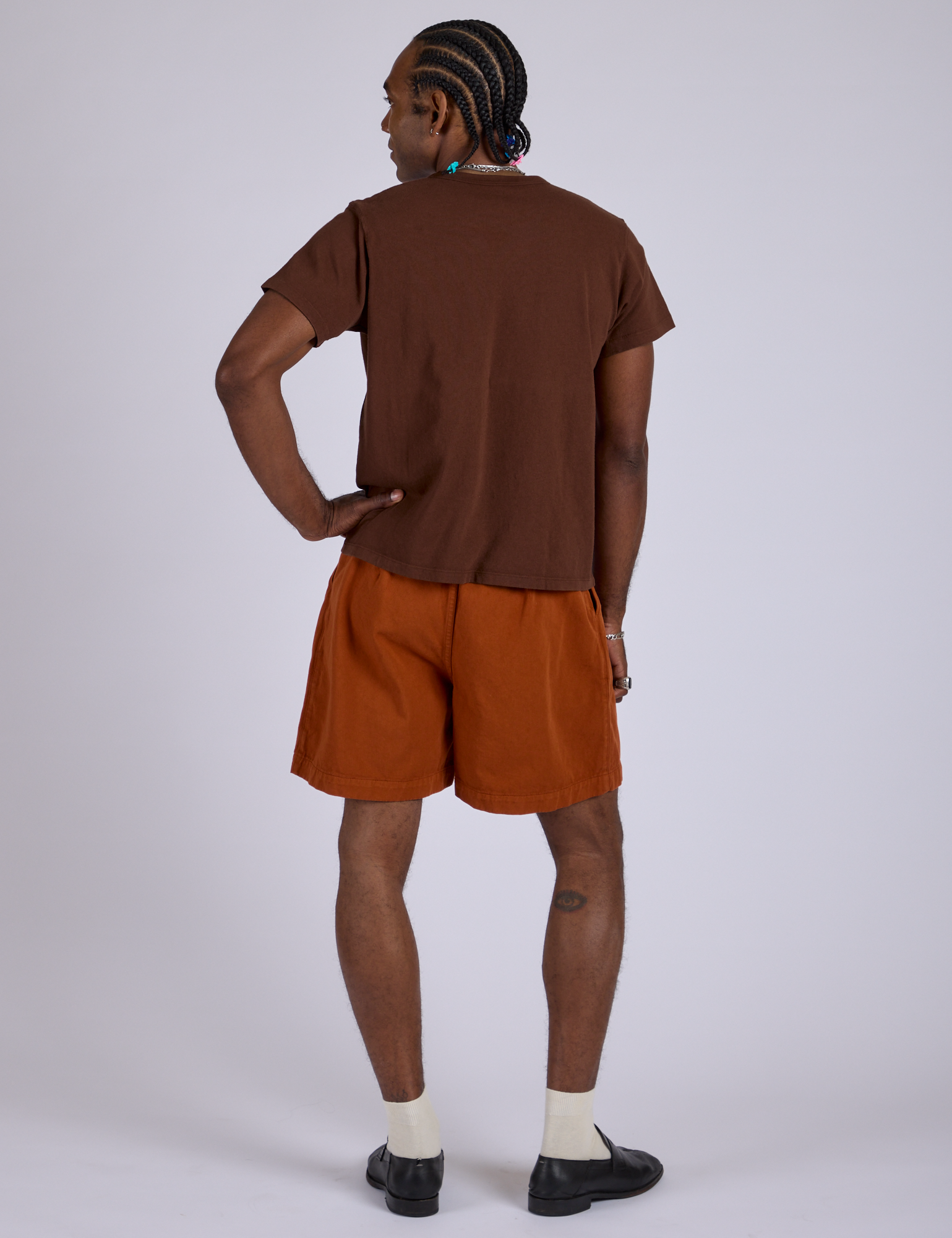 Back view of Pleated Trouser Shorts in Burnt Terracotta and fudgesicle brown Organic Vintage Tee