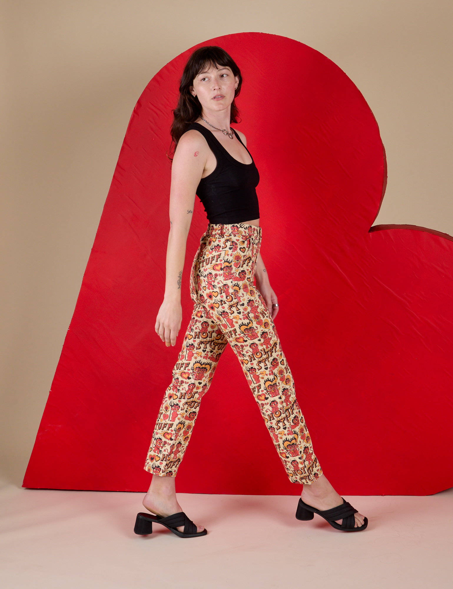 Side view of Work Pants in Hot Stuff Print and black Cropped Tank on Alex