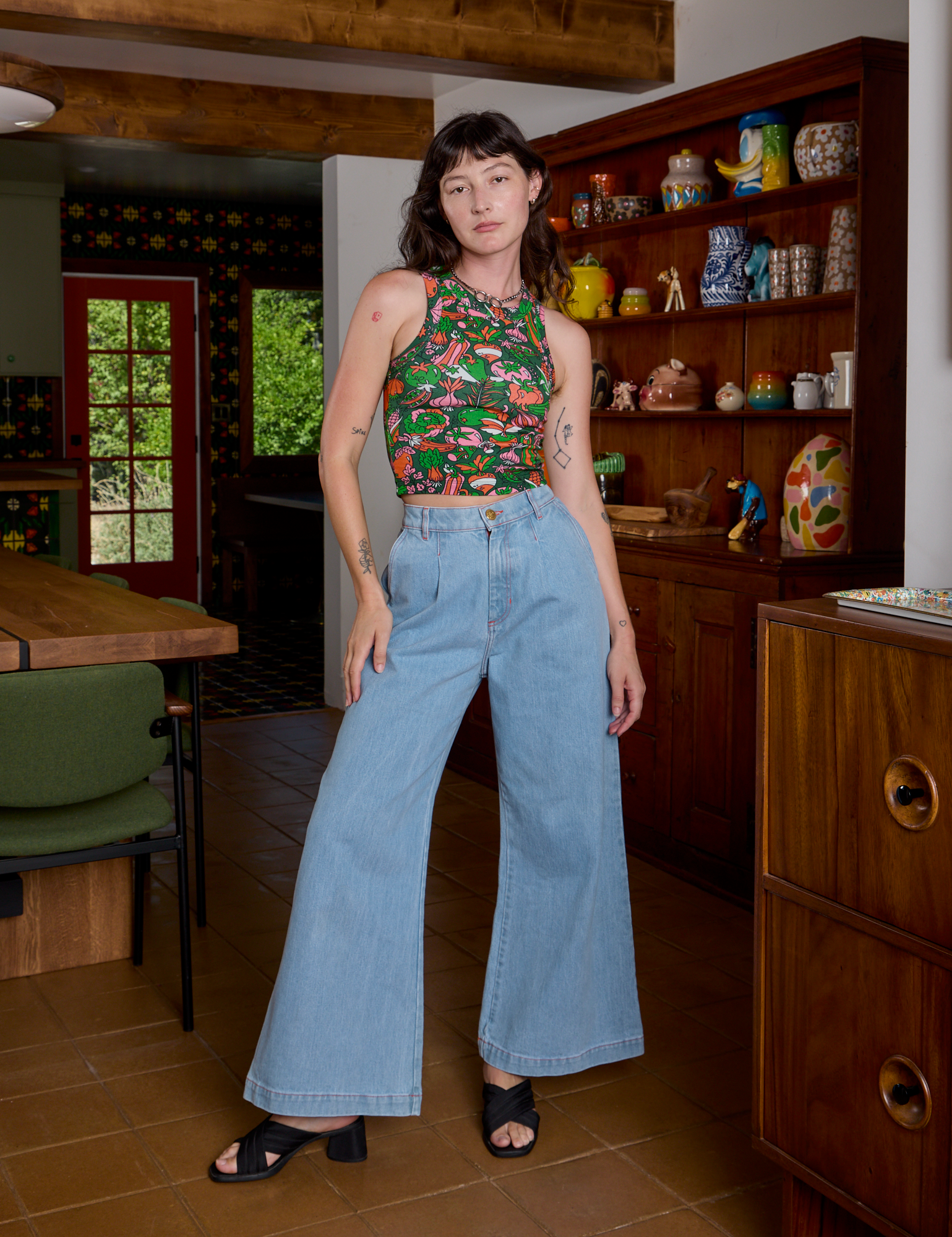 Alex is wearing Kitchen Collection Racerback Tank and light wash Indigo Wide Leg Trousers