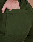Close up of Alex's hand in the back pocket of Classic Work Shorts in Evergreen