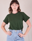 Alex is wearing Burly Tee in Swamp Green tucked into light wash Denim Wide Leg Trousers