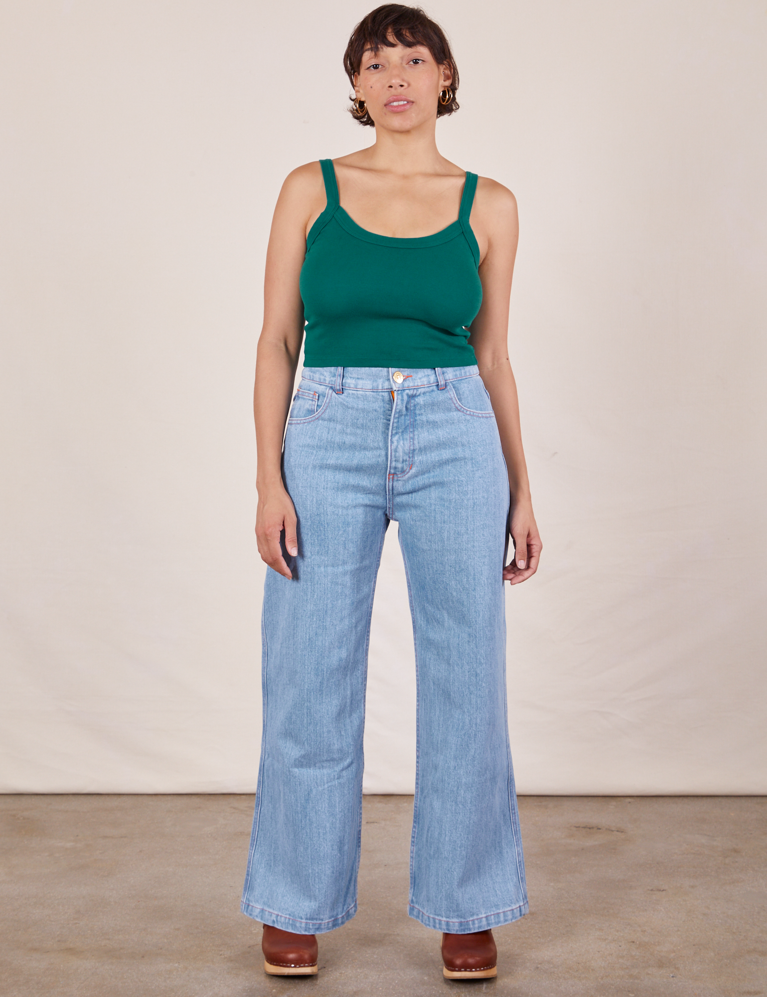 Tiara is wearing Cropped Cami in Hunter Green and light wash Sailor Jeans