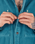 Front close up of Corduroy Overshirt in Marine Blue. Jesse is buttoning the shirt.