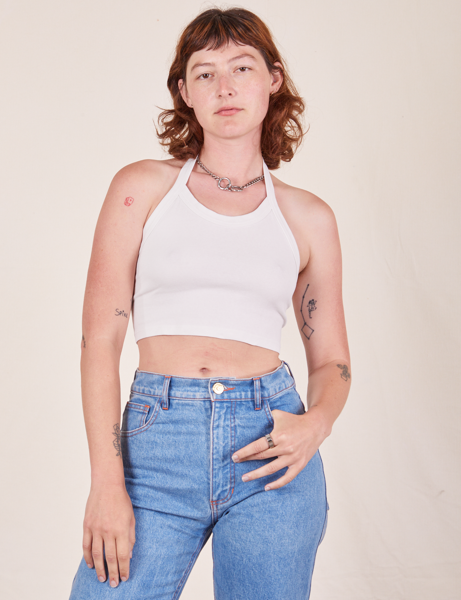 Alex is 5&#39;8&quot; and wearing P Halter Top in Vintage Off-White paired with light wash Frontier Pants