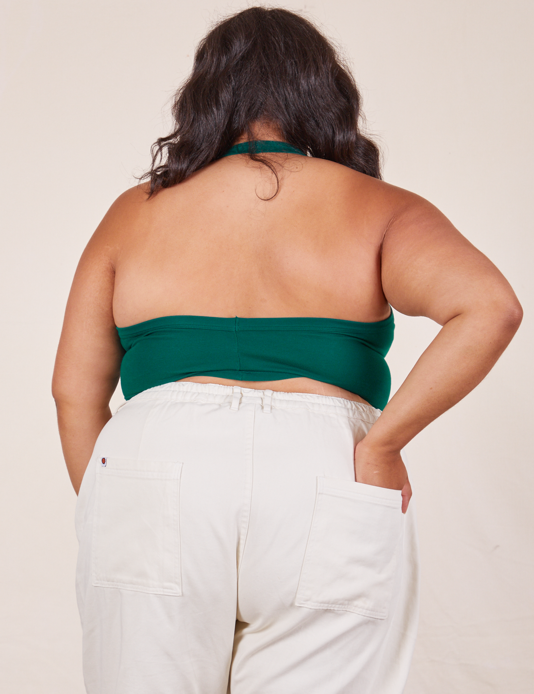 Back view of Halter Top in Hunter Green and vintage off-white Western Pants worn by Alicia. She has her left hand in the back pocket of the pants.