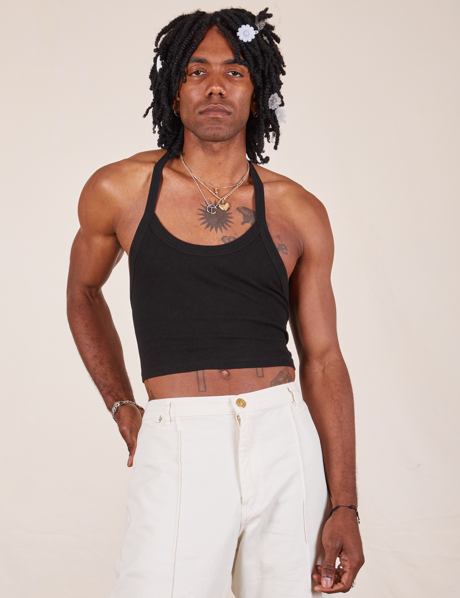 Jerrod is 6&#39;3&quot; and wearing XS Halter Top in Basic Black paired with vintage off-white Western Pants