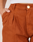 Front pocket close up of Heavyweight Trousers in Burnt Terracotta. Tiara has her hand in the pocket.
