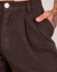 Front close up of Heavyweight Trousers in Espresso Brown. Jesse has their hand in the pocket.