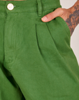 Front pocket close up of Heavyweight Trousers in Lawn Green. Jesse has their hand in the pocket.