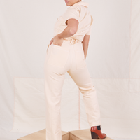 Heritage Short Sleeve Jumpsuit in Natural back view. Worn by Tiara with left hand in left back pocket
