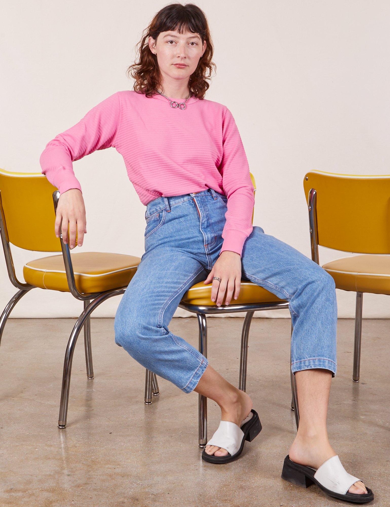 Alex is wearing Honeycomb Thermal in Bubblegum Pink and light wash Frontier Jeans