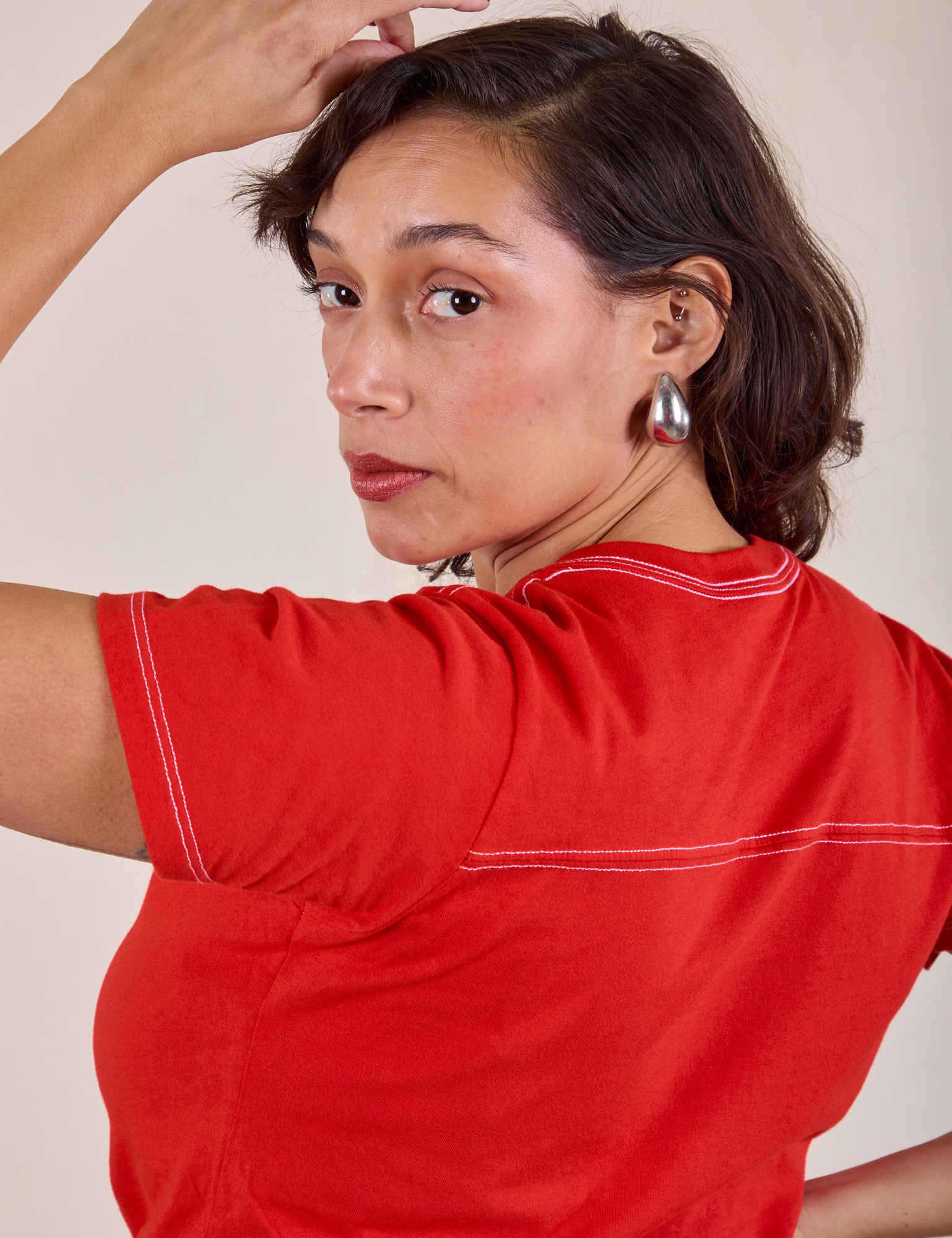 JV Tee in Mustang Red back view close up on Tiara. Decorative contrast white stitching on shirt.