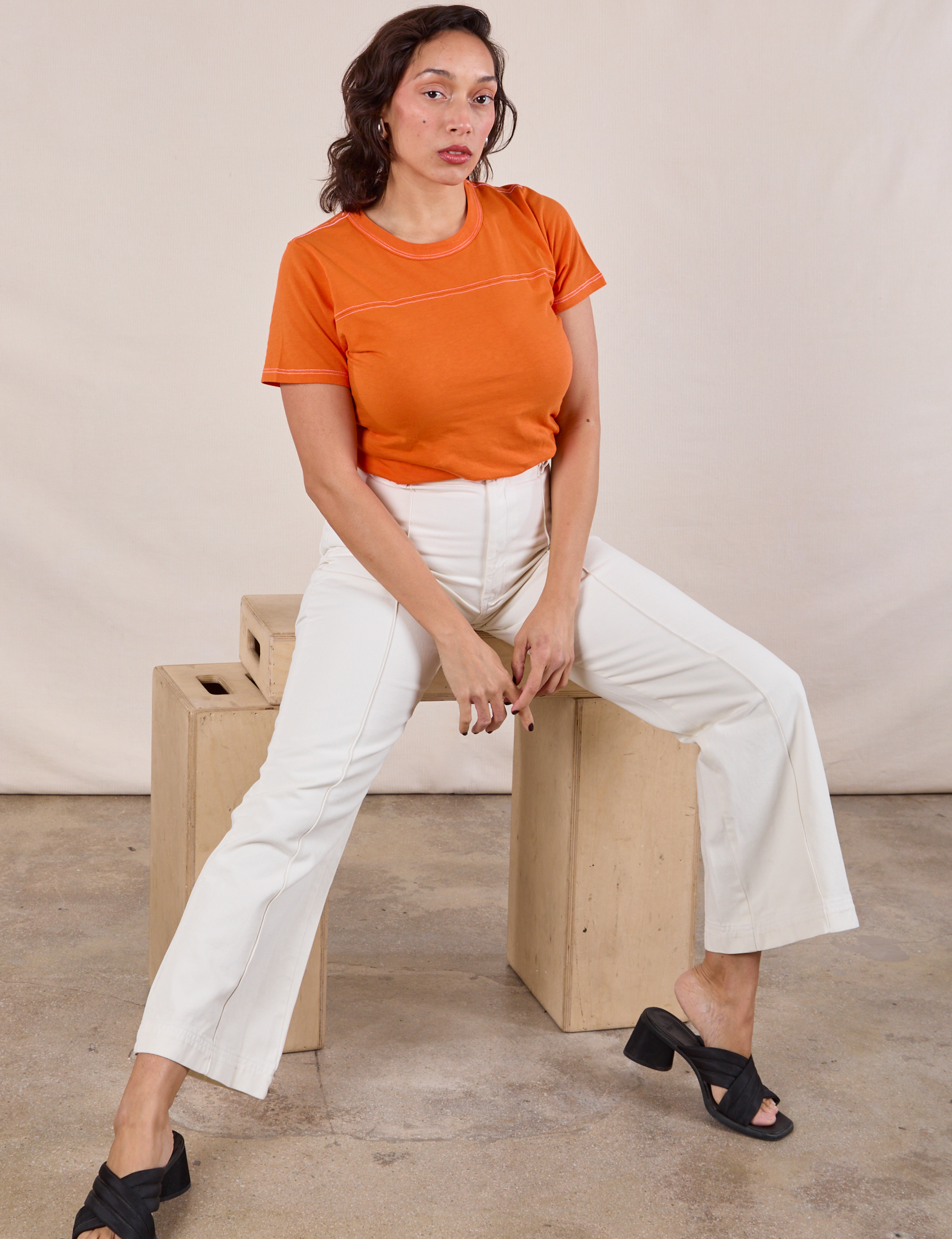 Tiara is wearing JV Tee in Construction Orange and vintage tee off-white Western Pants