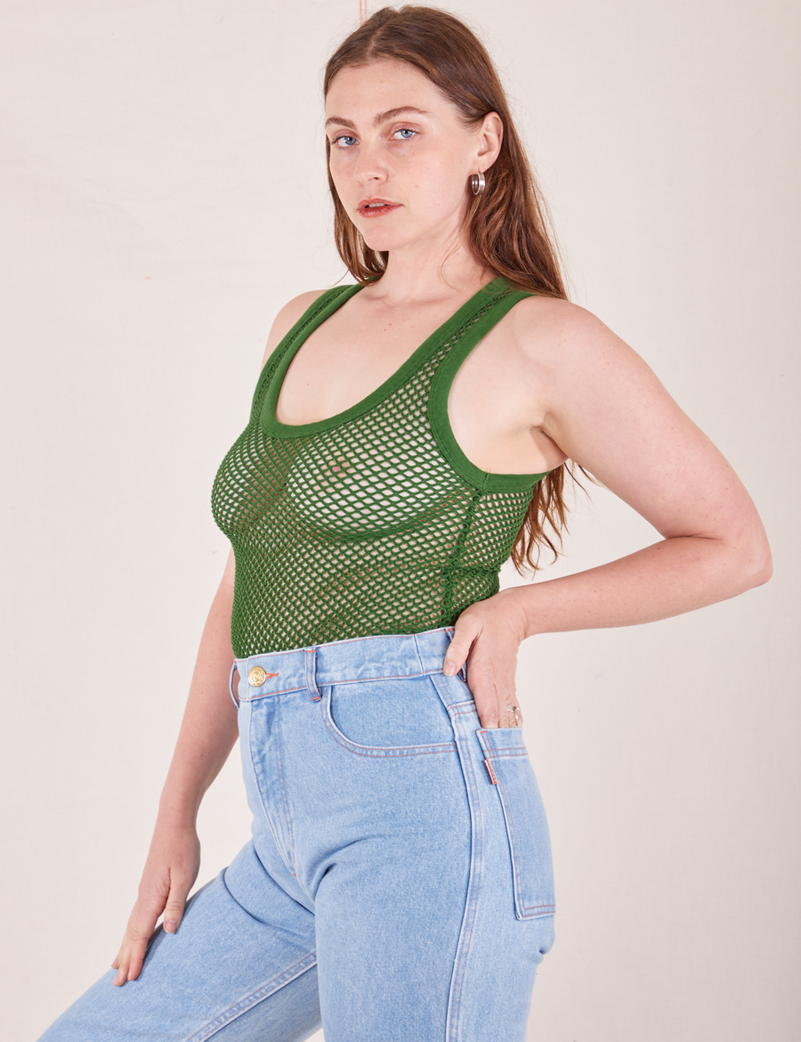 Angled view of Mesh Tank Top in Lawn Green and light wash Sailor Jeans worn by Allison