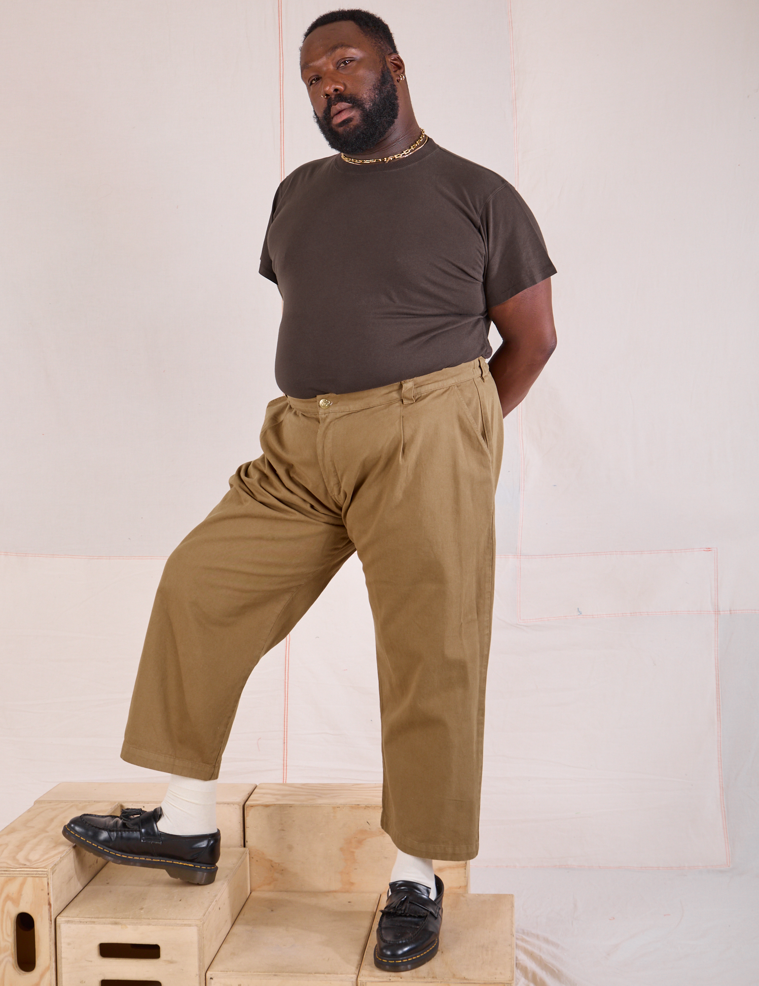 Angled front view of Mid-Rise Pleated Trousers in Desert Brown and espresso brown on Elijah